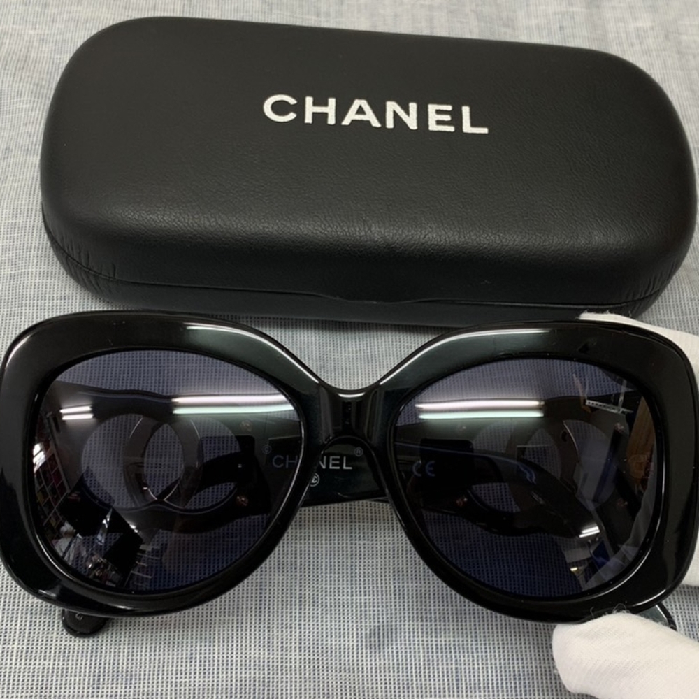 A pair of dark, luxurous Chanel sun glasses
